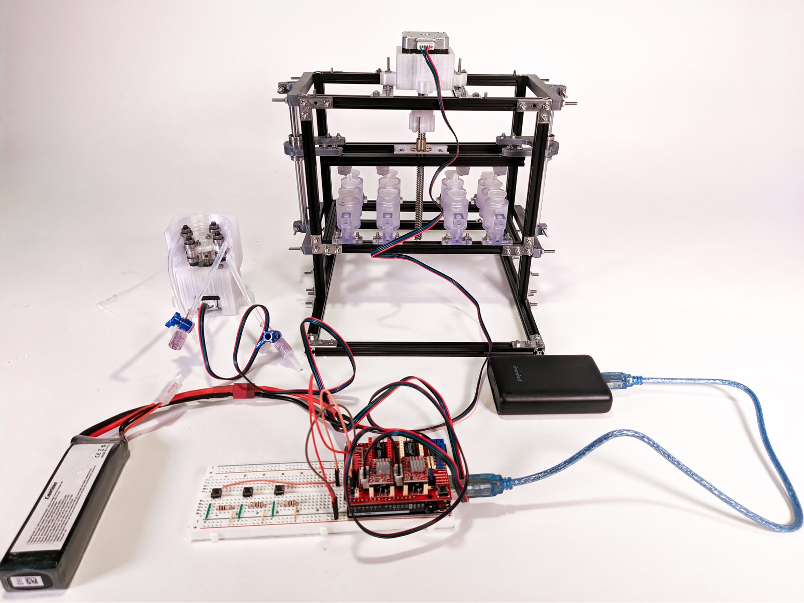 The whole system. Bioreactor frame with the actuation motor on top, the custom peristaltic pump (left), and the Arduino UNO + CNC-shield electronics that stay outside the incubator.