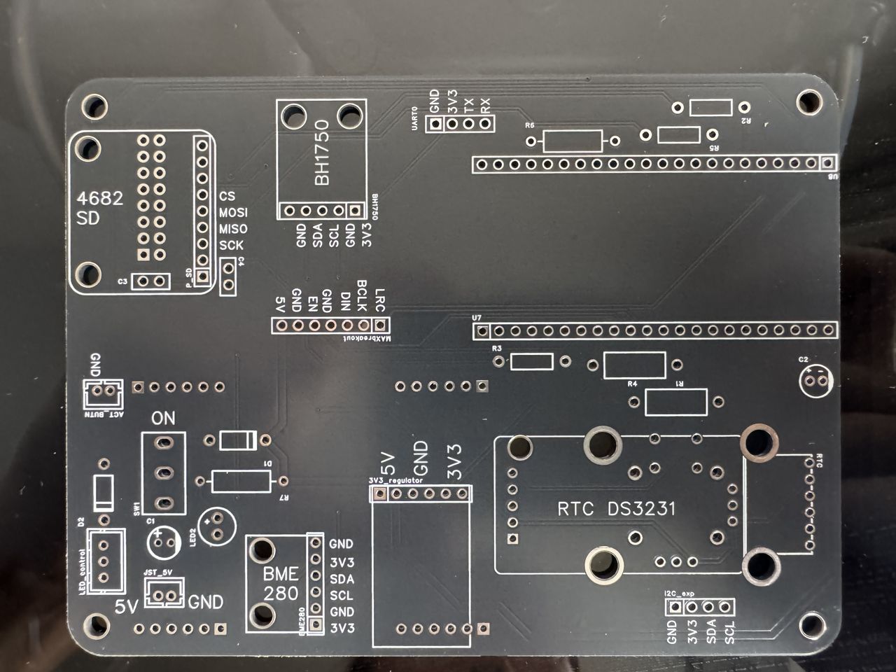 The bare main PCB, revision 2, back face, showing silkscreen labels for each module position