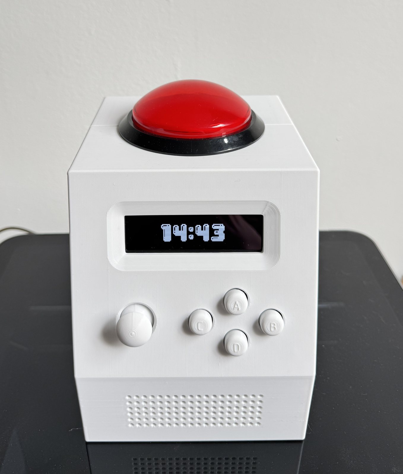The finished unit. 140 by 160 by 170 mm, 3D printed in two parts, with the 100 mm arcade button on top and the control face raked back for a bedside viewing angle.